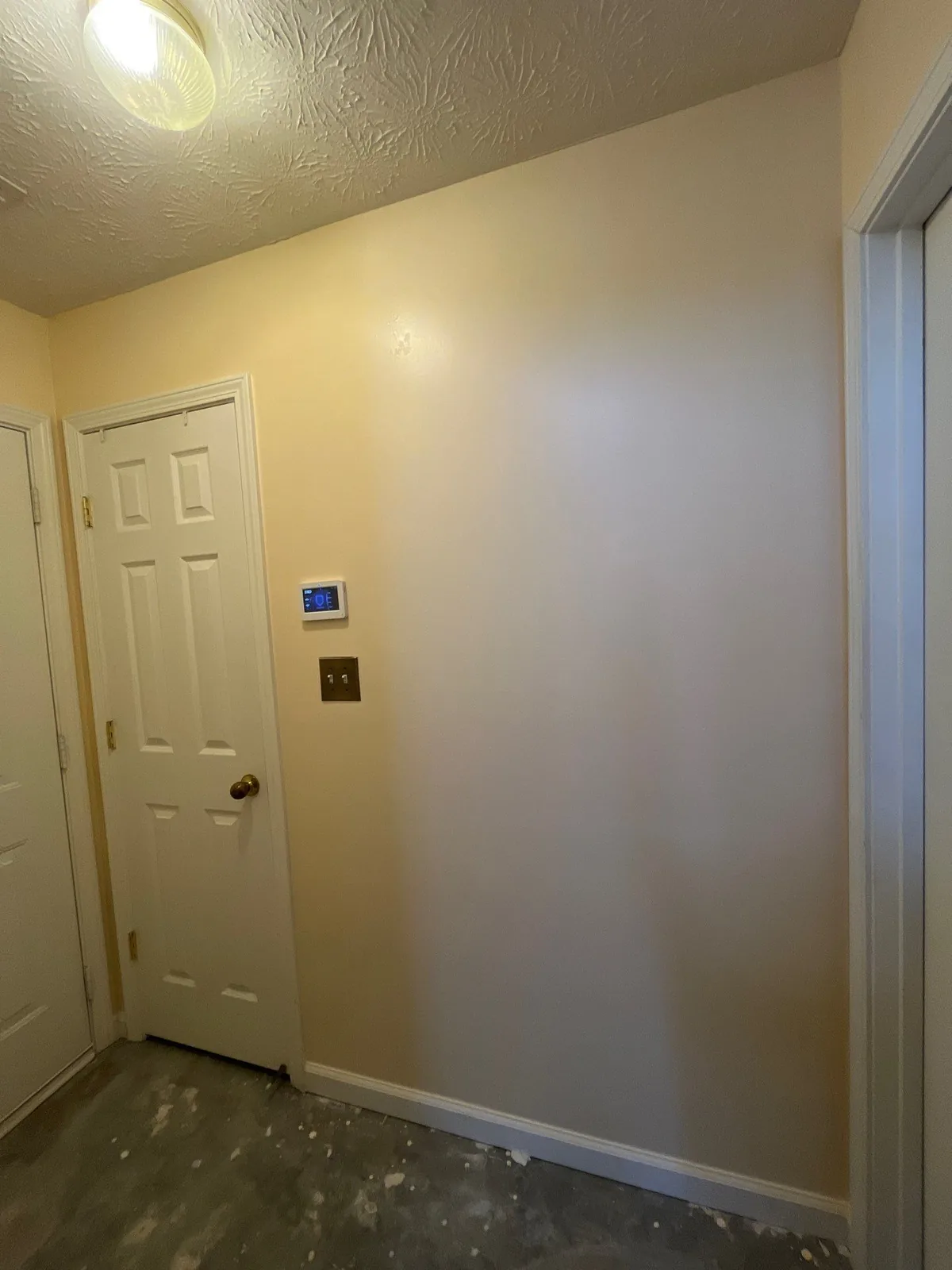 Hallway with beige walls and unfinished flooring during construction — serving Dallas, GA.