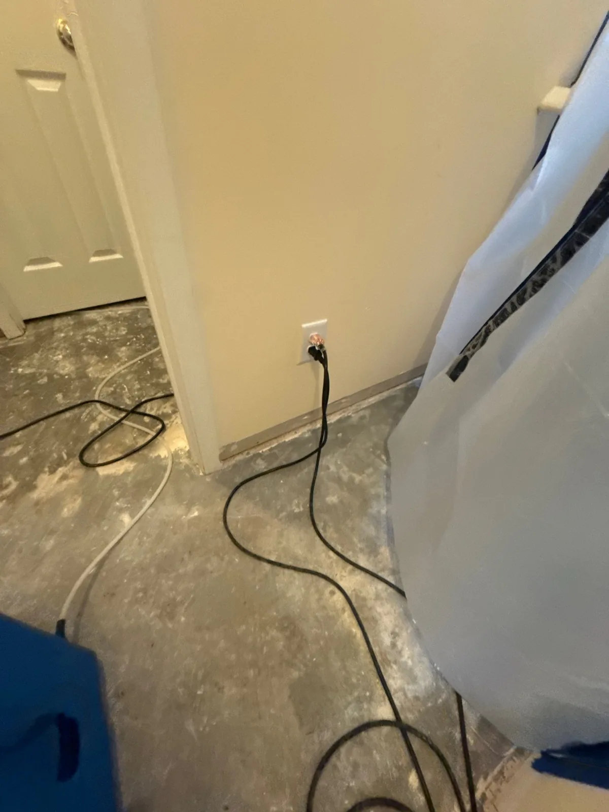 Room with bare concrete floor and electrical cords during water mitigation — serving Dallas, GA.