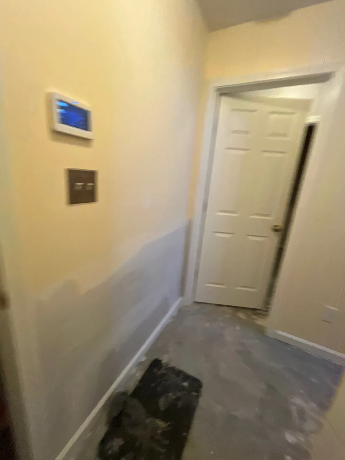 Hallway under restoration with patched wall and exposed concrete floor — serving Dallas, GA.