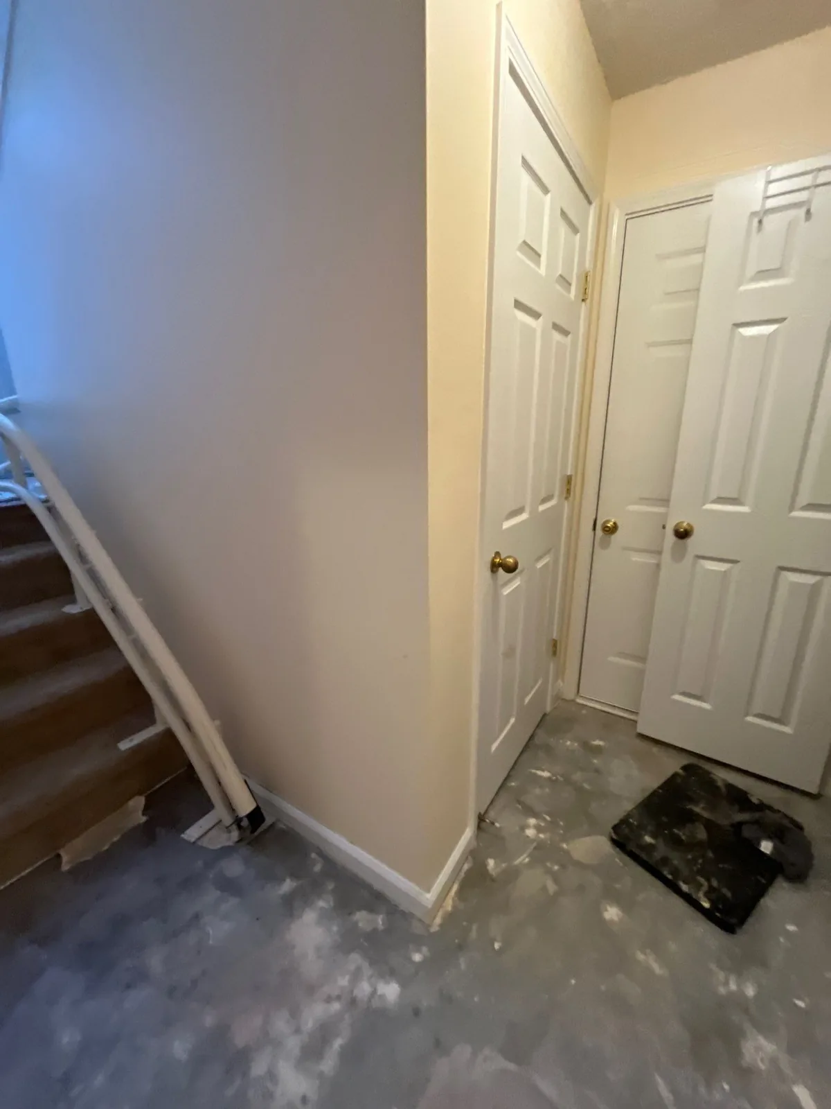 Construction work in progress near stairs with doors, showing a repaired floor area — serving Dallas, GA.