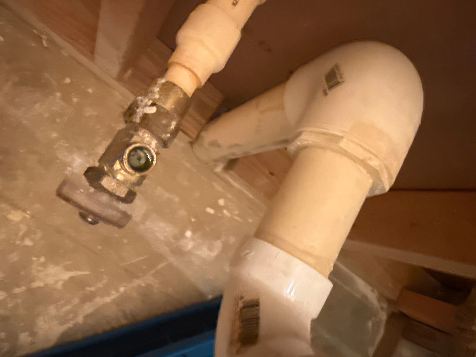 Close-up of plumbing pipes and fittings under a sink in a water mitigation project — serving Dallas, GA.