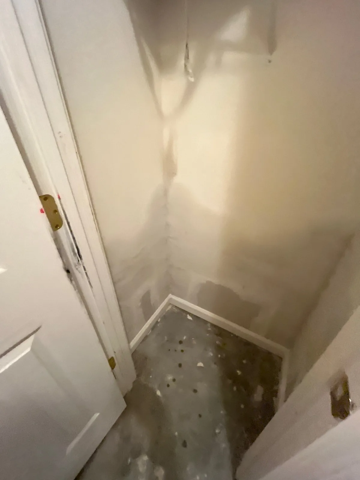 Water damage mitigation work in a room corner with stained walls and visible patches — serving Dallas, GA.