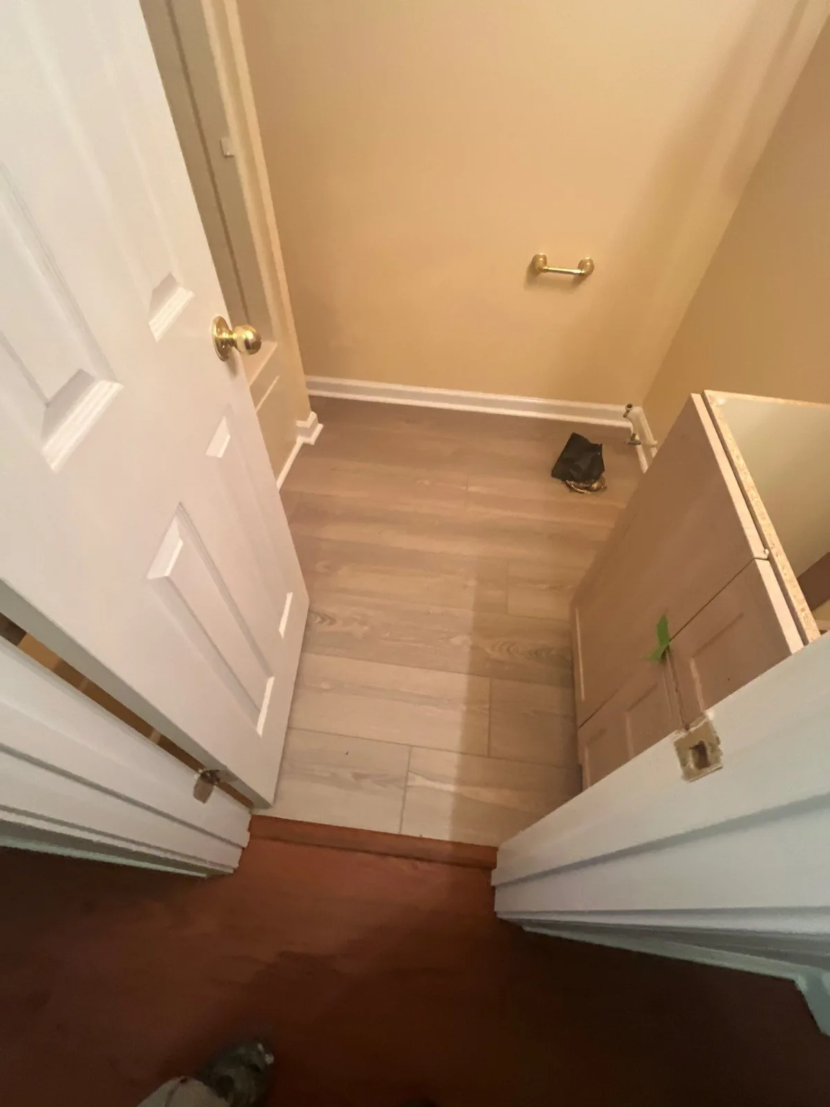 View of a small room under renovation with new wooden flooring and an unpainted cabinet — serving Dallas, GA.