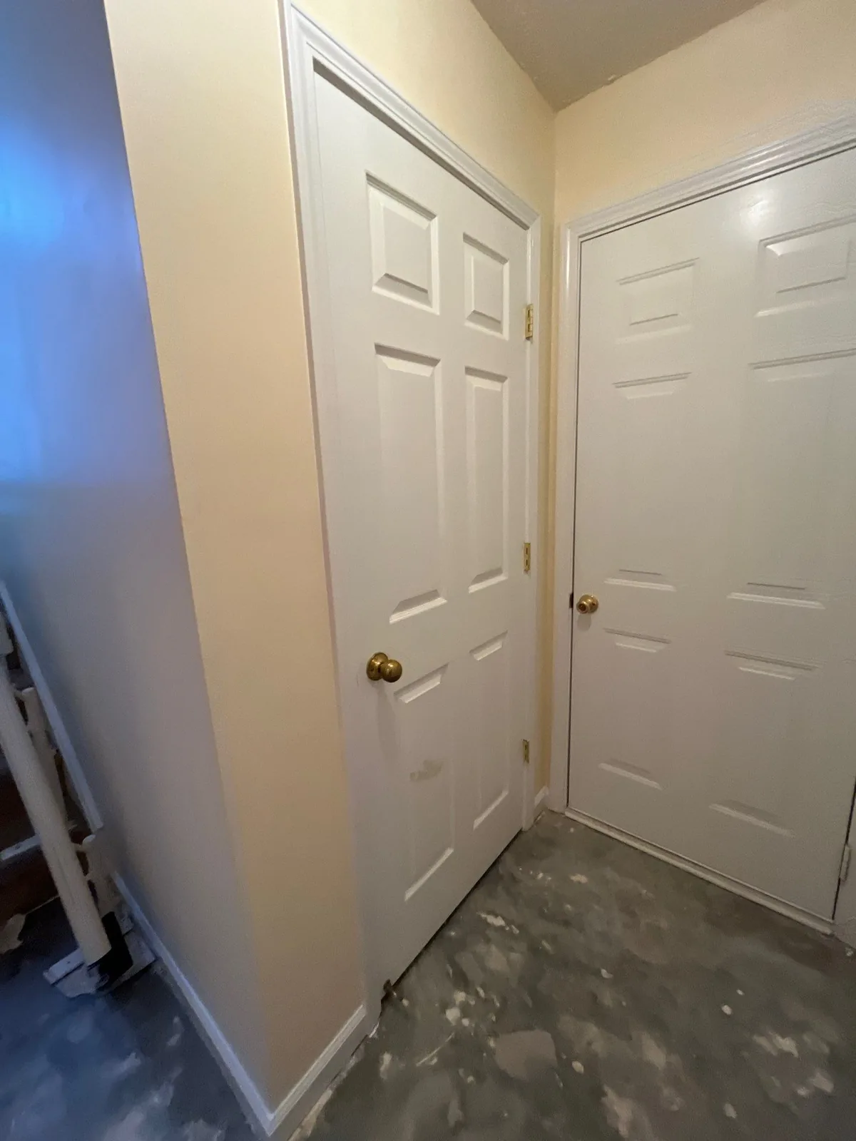 Hallway corner with two white interior doors and an unfinished floor — serving Dallas, GA.