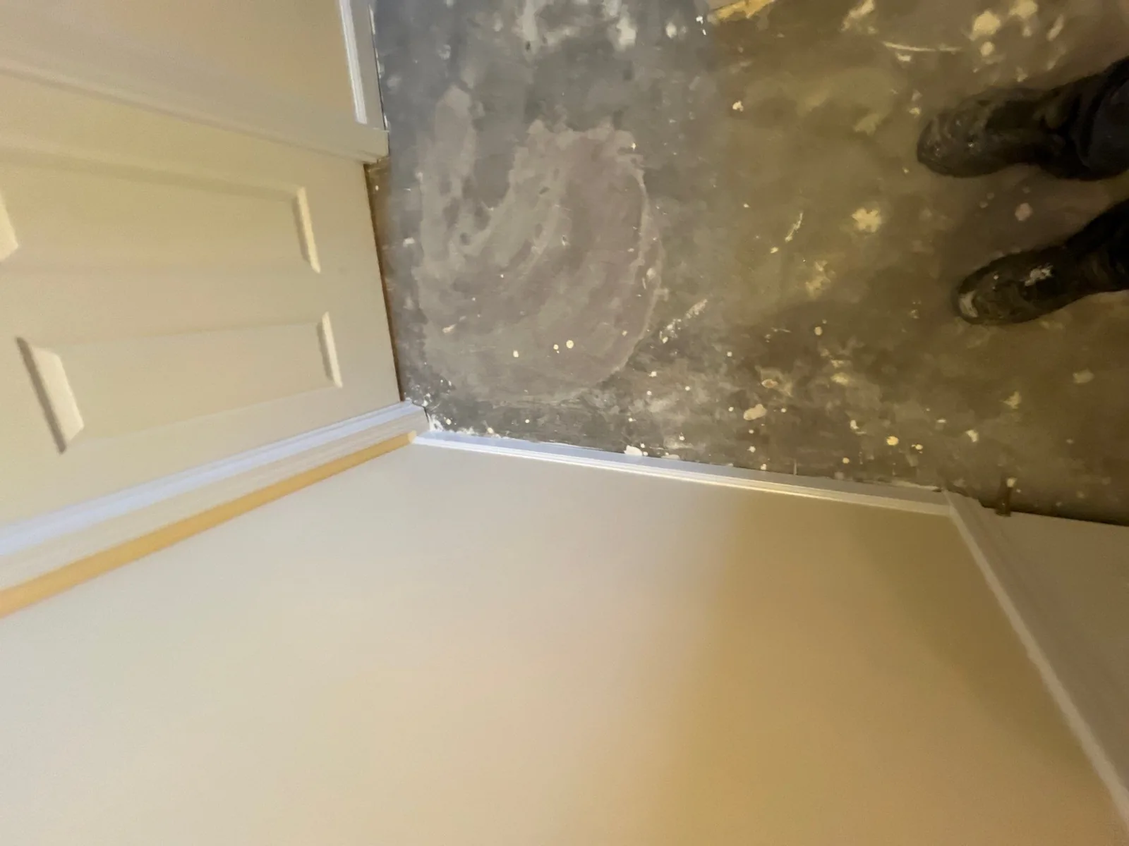 Room corner with unfinished floor and freshly painted walls during renovation — serving Dallas, GA.