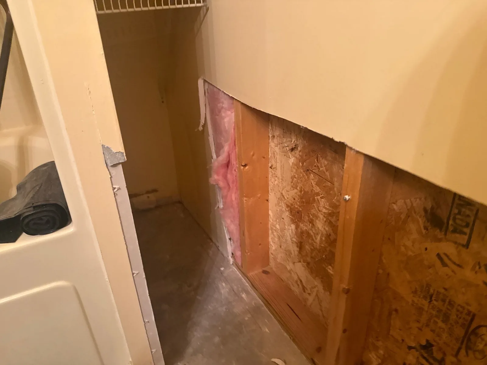 Partially demolished wall with exposed insulation and wooden studs during water mitigation — serving Dallas, GA.