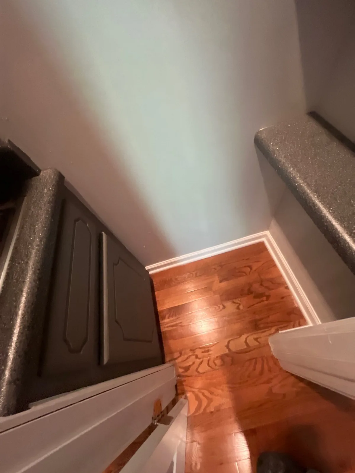 Corner of a room with newly finished hardwood flooring and dark countertops, indicating a completed remodeling phase — serving Dallas, GA.