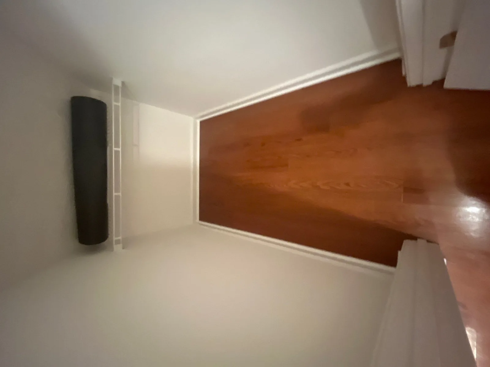 Completed closet remodel with wooden flooring and a white shelf — serving Dallas, GA.