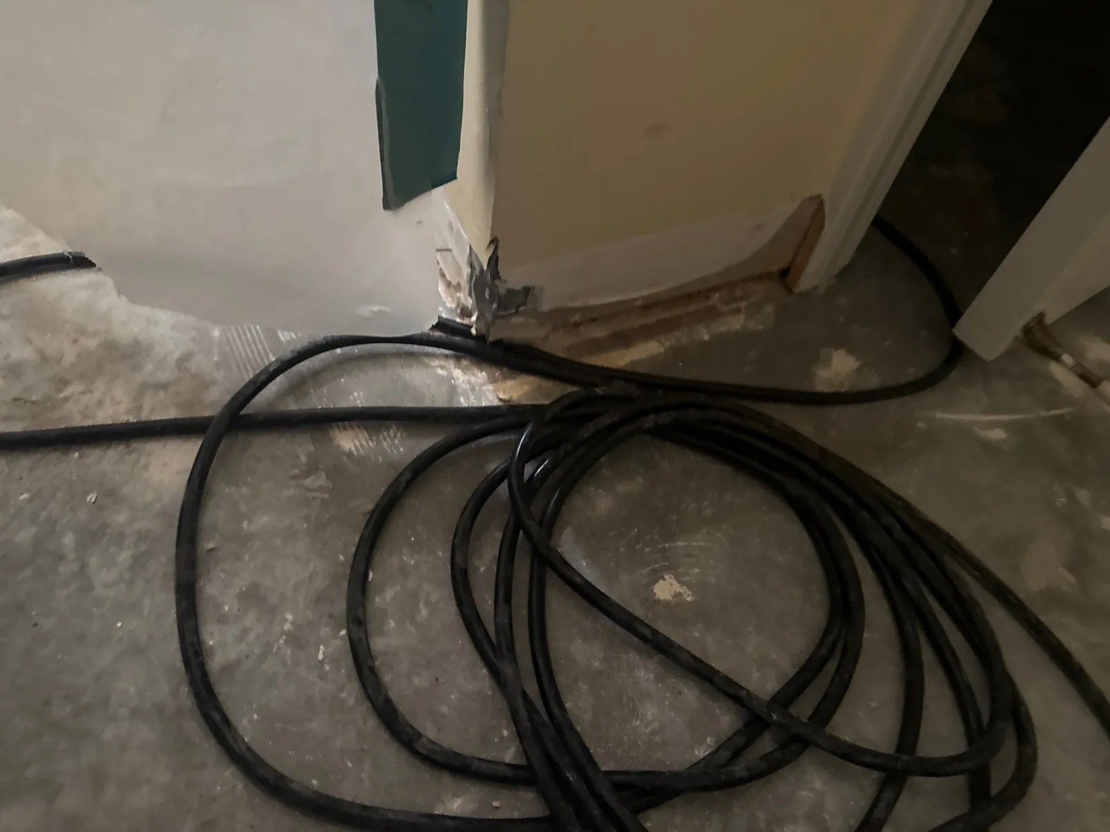 Water mitigation setup with cables coiled on a concrete floor near a wall — serving Dallas, GA.