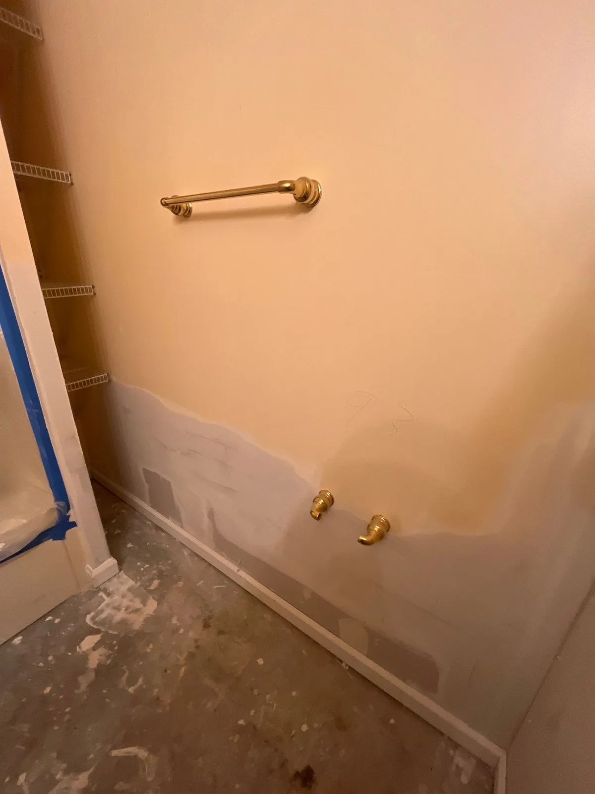 Bathroom under renovation with partially painted wall, exposed plumbing, and towel rack — serving Dallas, GA.
