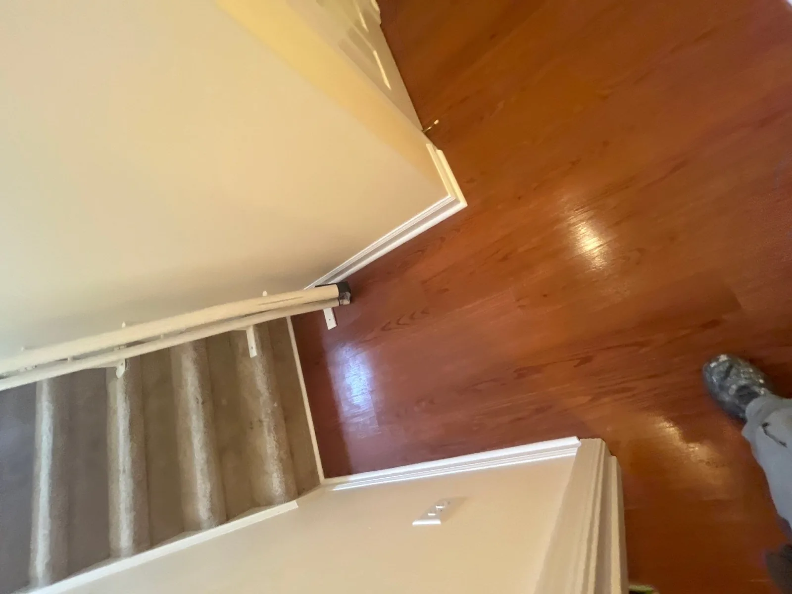 View of newly installed hardwood floor meeting carpeted stairs after remodeling — serving Dallas, GA.