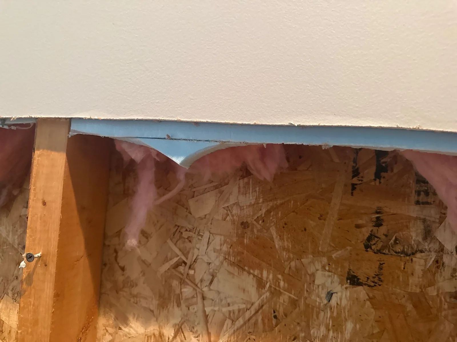 Close-up of drywall removed to show insulation and wooden framework — serving Dallas, GA.