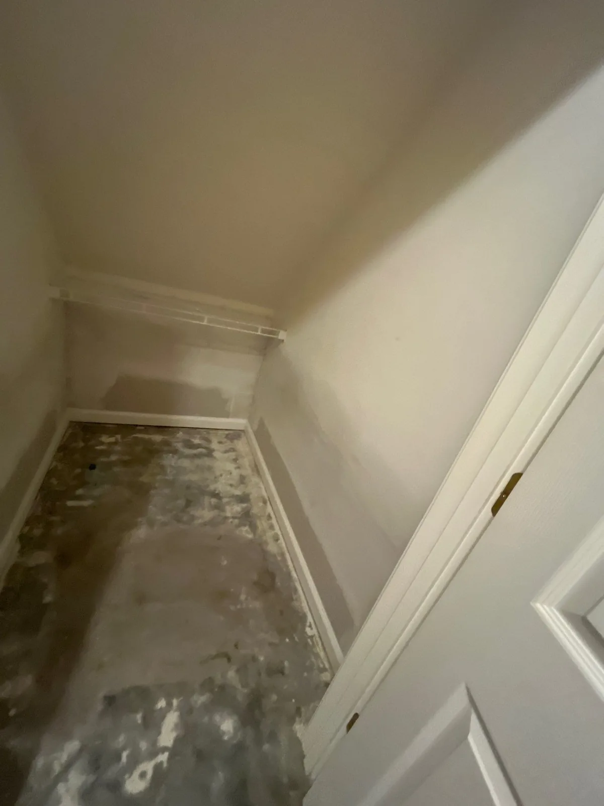Empty closet with unfinished floor and painted walls, showing a progress stage in construction — serving Dallas, GA.