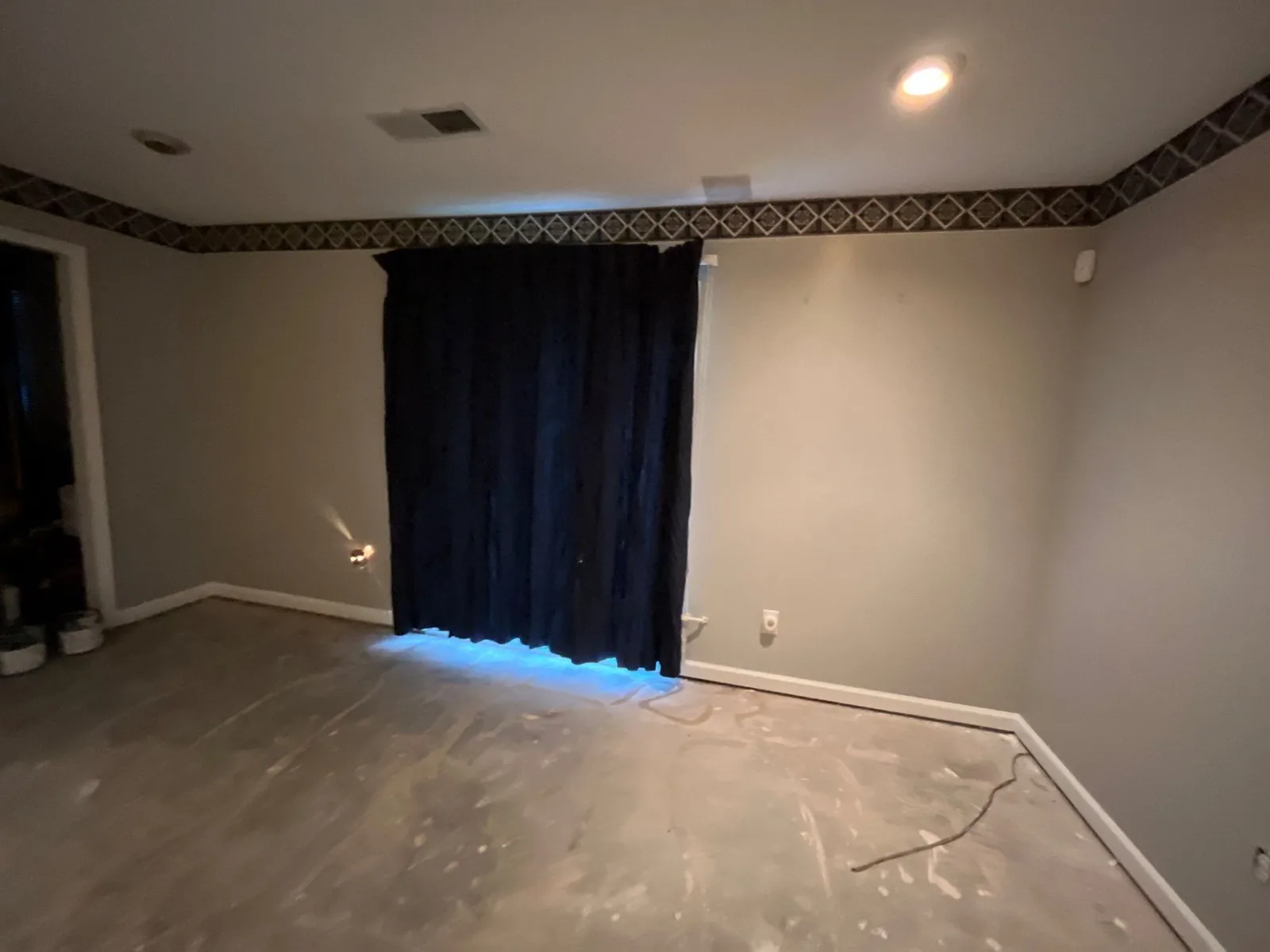 Room undergoing construction with unfinished floor and curtains over window — serving Dallas, GA.
