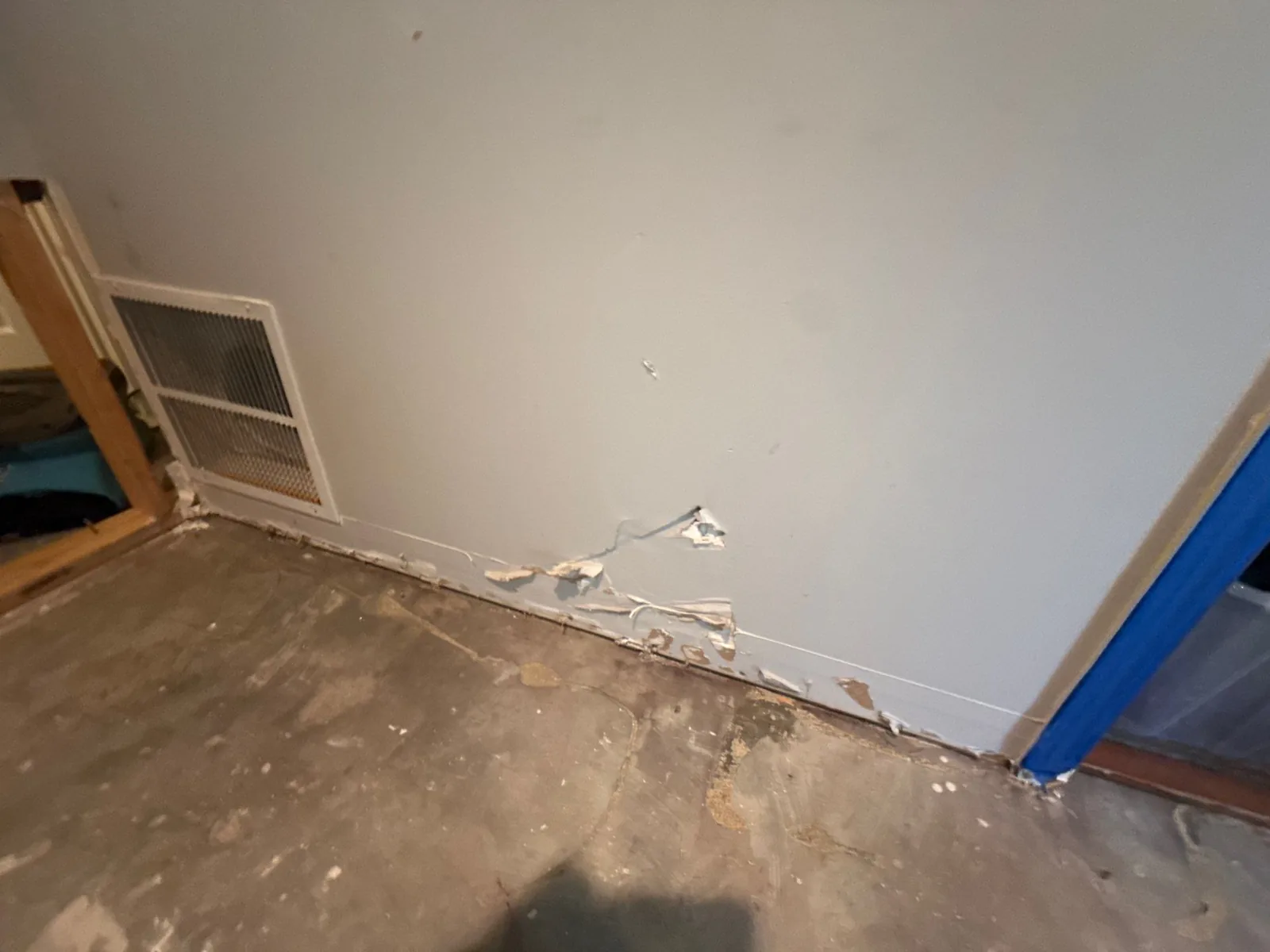 Interior wall showing water-damaged paint and baseboard near a vent — serving Dallas, GA.