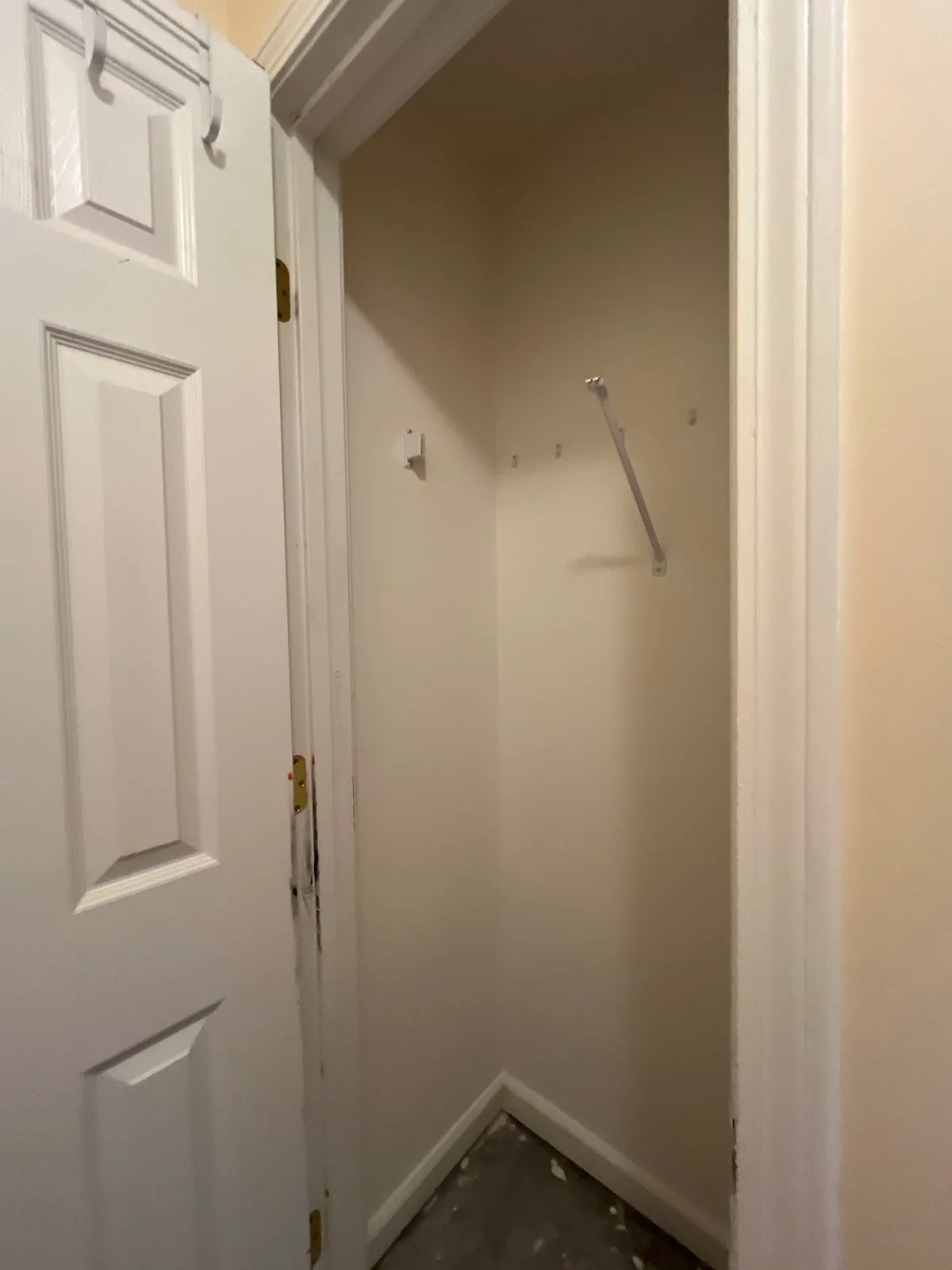 Interior view of a small closet with a partially opened door, showing a metal bracket on the inside wall — serving Dallas, GA.