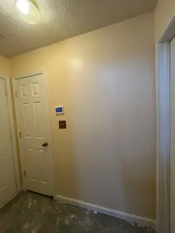 Hallway with beige walls and unfinished flooring during construction — serving Dallas, GA.