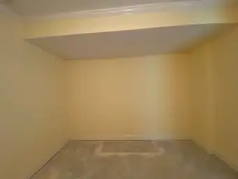 Basement room with bare concrete slab stripped to raw state before flooring reinstall after water damage remediation — Marietta, GA