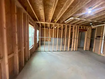 Basement completion showing open wood stud framing across wide floor plan with concrete slab and new windows — Metro Atlanta, GA