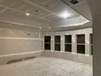 Freshly drywalled basement room with large bay window openings and recessed ceiling tray taking shape — Atlanta, GA