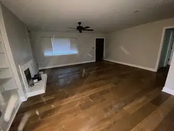 Stripped interior walls during water damage restoration exposing pine framing, black drain pipe, and new plank flooring — Kennesaw, GA