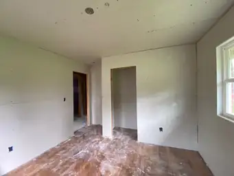Interior attic rafter framing surrounding existing window opening during window installation phase of home remodel — Marietta, GA