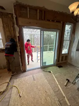 Contractors installing new sliding glass door from exterior — framing and door installation during kitchen renovation — Powder Springs, GA