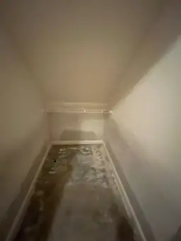 A small closet under construction with concrete floor, wire shelf, and unfinished drywall — serving Dallas, GA.