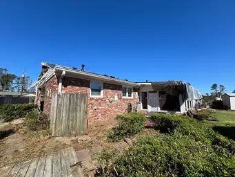 Brick ranch exterior with blue tarp covering storm-damaged roof after emergency dry-out — Marietta, GA