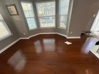 Restored interior after water damage with polished dark hardwood floors, grey walls, and large bay window trim — Smyrna, GA