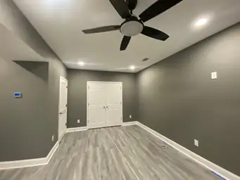 Completed basement bedroom with charcoal walls, white double closet doors, recessed lighting, and ceiling fan — Metro Atlanta, GA