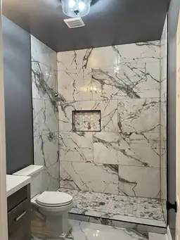 Bathroom renovation with floor-to-ceiling Calacatta marble tile, hexagon niche, and frameless glass shower — Metro Atlanta, GA