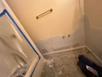Bathroom under renovation with exposed flooring, partially painted walls, and a covered bathtub — serving Dallas, GA.