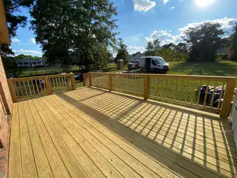 Completed gray composite deck with white balusters and railing after staining on finished home addition project — Marietta, GA