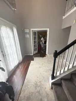Two-story foyer during water damage repair with subfloor exposed mid-installation and hardwood planks at entry — Smyrna, GA
