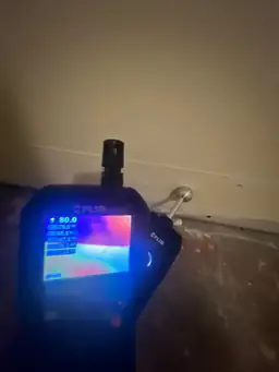 FLIR moisture meter reading 80% relative humidity against wet concrete floor during basement water damage assessment — Marietta, GA
