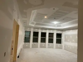 Drywall mudded on curved bay window wall with five windows and recessed platform framed in basement — Atlanta, GA