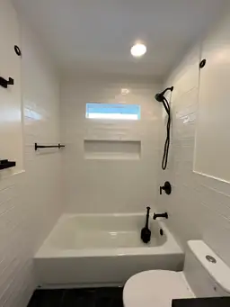 Second bathroom before remodel showing gutted original condition with bare walls and dated fixtures removed — Marietta, GA