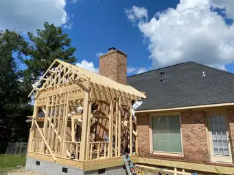 Full rear exterior view of completed home addition with tan fiber cement siding, gray composite deck, and white railing — Marietta, GA