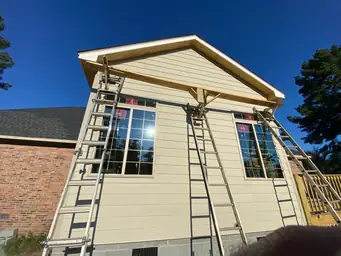 Sunroom addition exterior with 84 Lumber house wrap over CMU block foundation and wood deck framing during construction — Marietta, GA