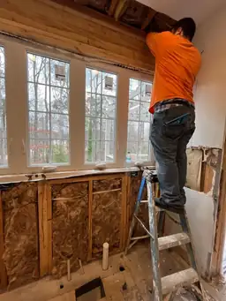 Contractor installing new windows during kitchen renovation — exterior wall framed with new window set in opening — Powder Springs, GA