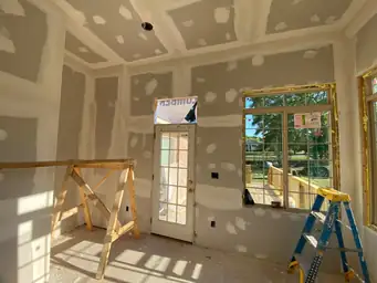 Sunroom addition coffered tray ceiling drywall mid-installation with French door to exterior and blue ladder visible — Marietta, GA
