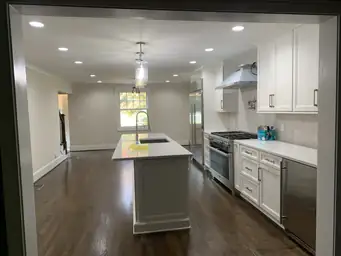 Open-concept kitchen renovation with white cabinetry, dark hardwood ceiling, glossy floors, and recessed lighting — Atlanta, GA