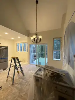 Open kitchen and dining area during renovation — vaulted ceiling, new chandelier, sliding glass door to deck roughed in — Powder Springs, GA