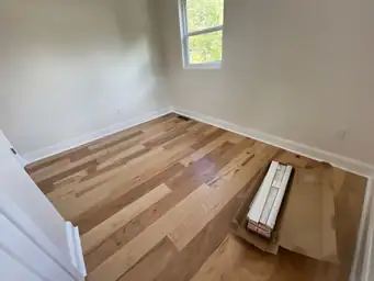Bedroom before home remodel with original worn subfloor exposed and unfinished patched walls in need of renovation — Marietta, GA