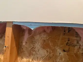 Close-up of drywall removed to show insulation and wooden framework — serving Dallas, GA.