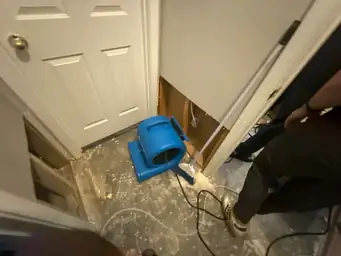 Dehumidifier in a room with exposed wall studs and concrete flooring, used during water mitigation — serving Dallas, GA.