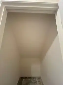 Empty closet with finished walls and an unfinished floor during remodeling — serving Dallas, GA.