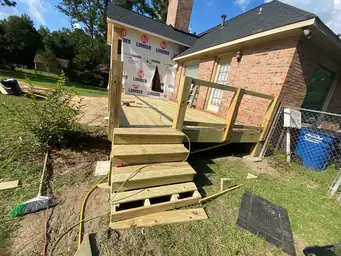 Ground-up home addition construction showing CMU block foundation, wood framing walls, and house wrap during progress — Marietta, GA