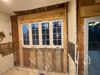 Kitchen exterior wall stripped to studs — new window installed in framing, electrical rough-in during renovation — Powder Springs, GA